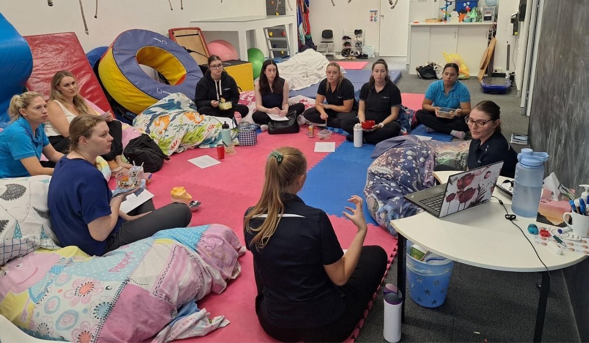 The Little Achievers team sitting together in the clinic planning therapy programs